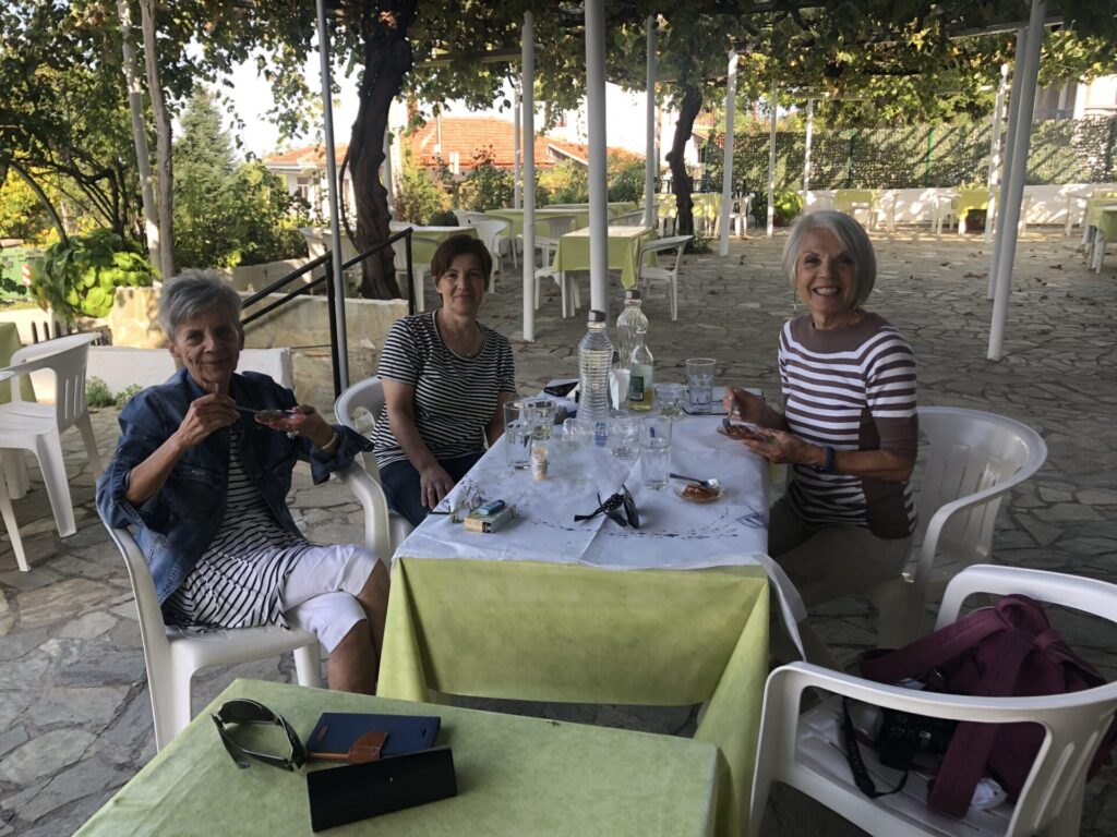 Three women at a table in Kostohori GreeceEating a traditional Greek cherry preserve