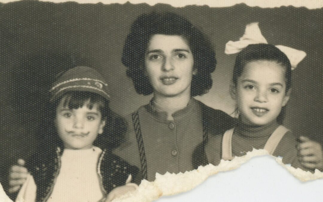 A WOMAN HOLDING 2 GIRLS ON EITHER SIDE OF HER