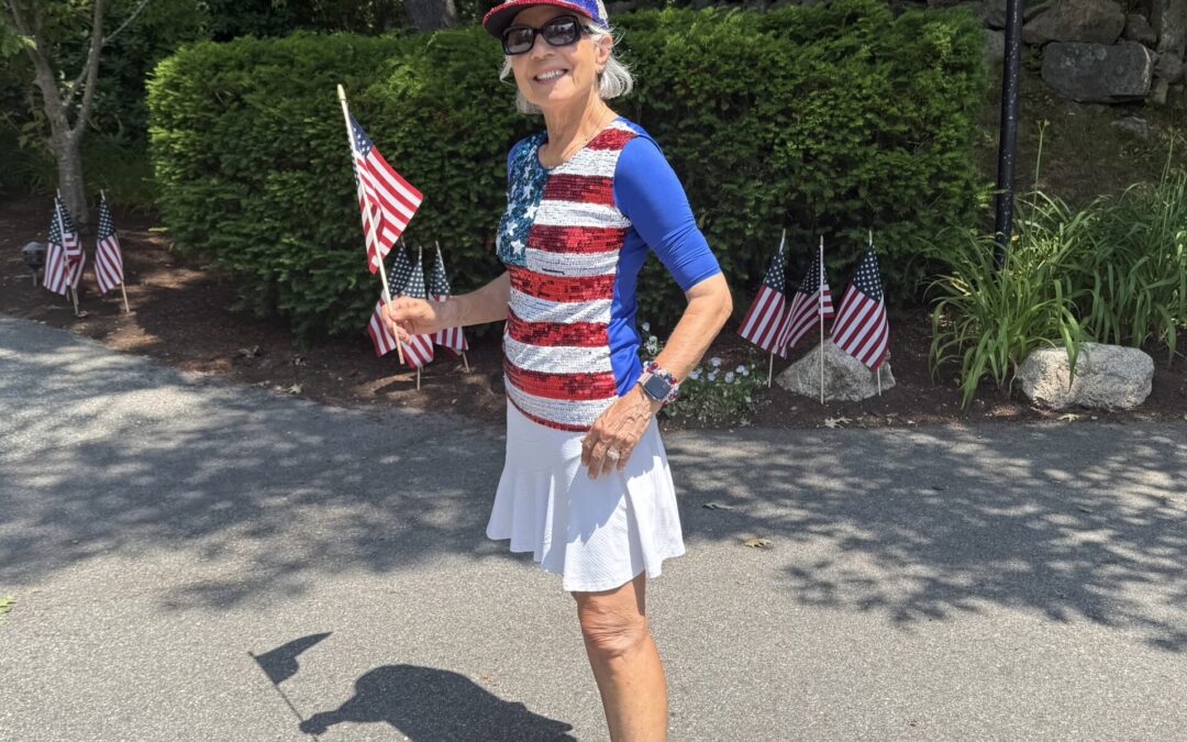 A woman dressed in red white and blue holding an American flag